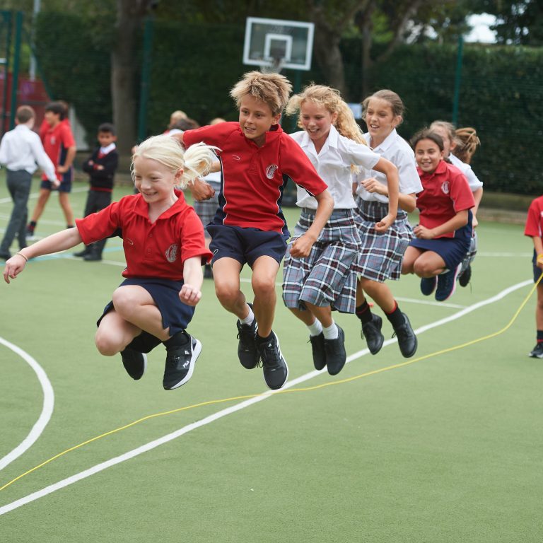 students jumping over a skipping rope