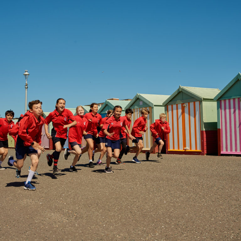 Students running on the beach