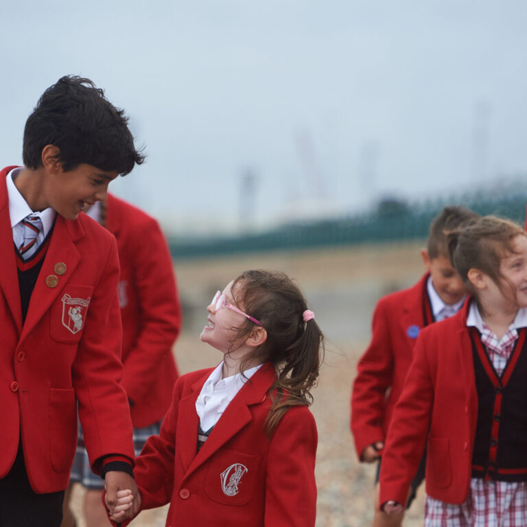 students holding the hands of their peers on a school trip