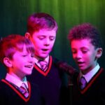 Students singing around a microphone