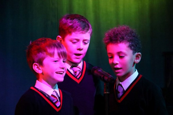 Students singing around a microphone