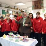students and teachers showing off cakes