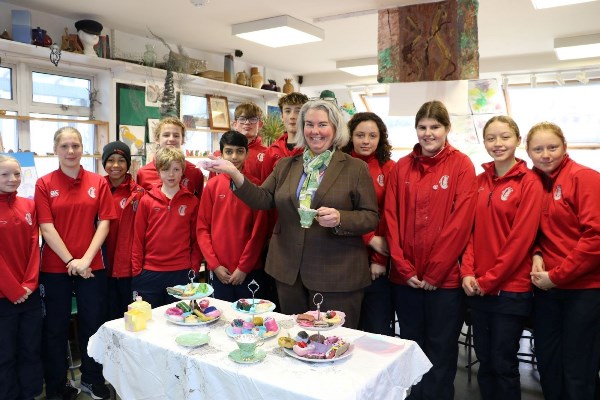 students and teachers showing off cakes